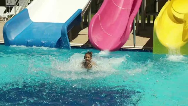child   on a water slide, slow motion