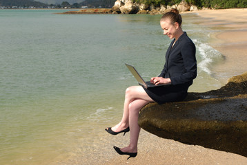 business woman working on laptop at beach