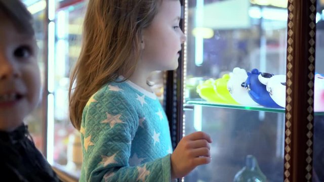 Children choose a toy in a shop window