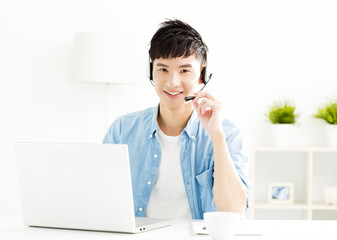 Happy young man with headset and laptop