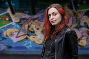 Fototapeta premium Young beautiful girl against graffiti