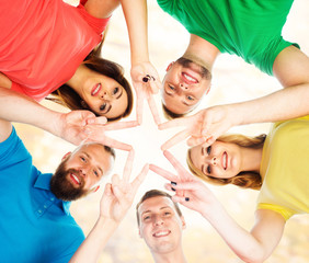 Smiling teenagers in colorful clothing standing together and making star with their fingers. Education, university, concept.