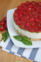 Cheesecake salata al formaggio e pomodori su piatto su tavolo di legno, Fuoco selettivo.