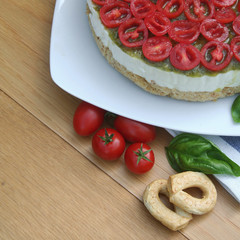 Cheesecake salata al formaggio e pomodori su piatto su tavolo di legno, Fuoco selettivo.