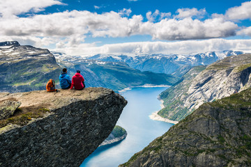 Couple sitting against amazing nature view on the way to Trolltunga. Location: Scandinavian...