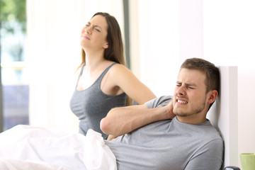 Couple suffering ache in a not comfortable bed