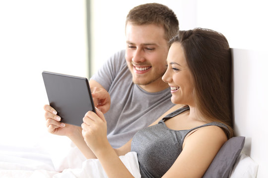 Couple watching media content on the bed