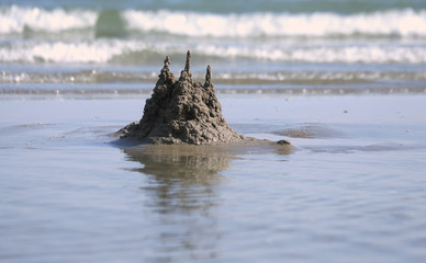 Sand castle on the shore of the sea similar to the famous Mont S