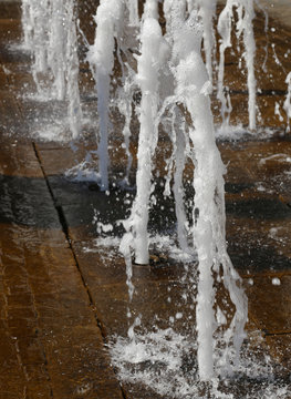 white foamy spray water of fountain in summer in a city