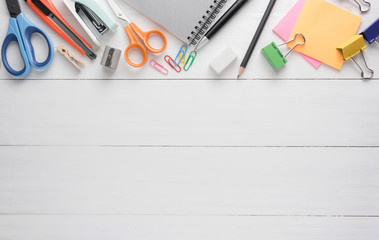 Small note book paper (notepad) for writing information with pencil and supplies stationery on wooden table. view from above