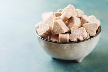 Heap of different sugar cubes shapes in a bowl. Selective focus.