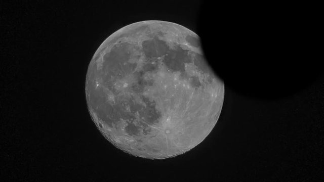 Video of a lunar eclipse over a big moon almost covered by the earth shadow