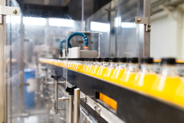Bottling factory - Orange juice bottling line for processing and bottling juice into bottles. Selective focus. 
