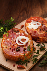 Marinated, raw pork ready for roasting on a wooden table.