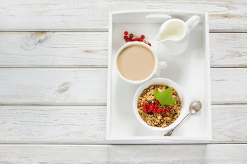 Summer healthy breakfast of granola, muesli with milk jug with red currant decor. Top view. Copy space.