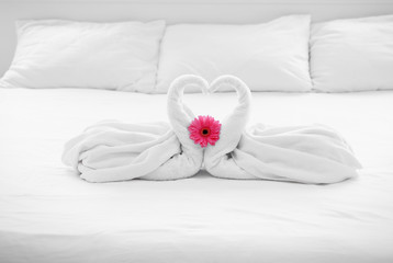 Two towel swans and flower on bed in hotel room © Africa Studio