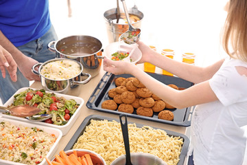 Volunteer giving food to girl. Poverty concept