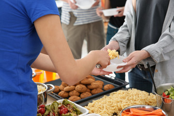 Volunteer sharing food with poor people. Poverty concept
