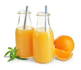 Composition with glass bottles of fresh juice and oranges on white background