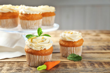 Composition with delicious carrot muffins on wooden table