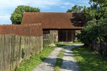 Fototapeta na wymiar Field path leading to an old barn
