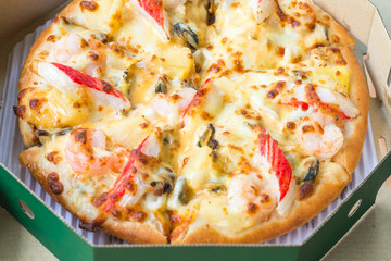pizza with seafood on delivery box