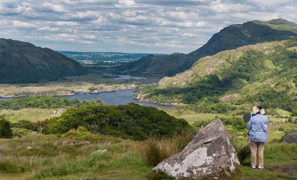 Tourists taking a photo of the scenic county Kerry landscape from Ladies view on the Ring of Kerry, Ireland
