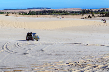 Off-road car with white sand dune desert and lake in Mui Ne, Vietnam, Southeast Asia