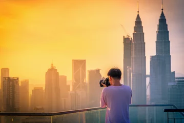 Rolgordijnen Fotografie neemt een foto van de skyline van de stad Kuala Lumpur op het dak van het hotel bij zonsopgang in Maleisië. © nuttawutnuy