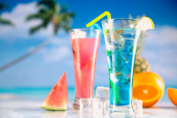Set of exotic drinks on the beach with blue ocean background