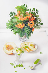Dessert from melon cottage cheese and mint bouquet of mountain ash