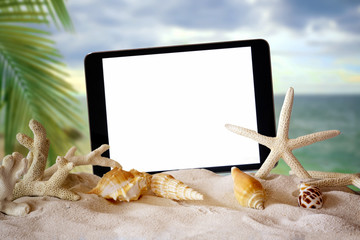 Summer background : Blank screen tablet with starfish, shells, coral on sand beach background.