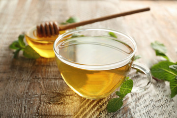 Cup of hot aromatic tea with lemon balm on wooden table