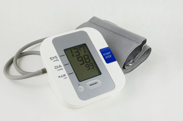 A personal blood pressure and heart rate meter on light background. The display indicates elevated blood pressure. Good image for health care