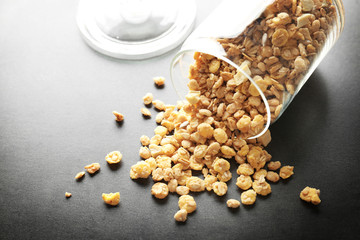 Glass jar with healthy breakfast cereal on gray background