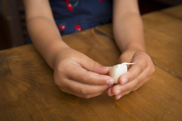 Children's hand peeling the garlic