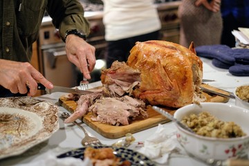 Family man carving a thanksgiving turkey