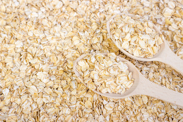 Oatmeal with a wooden spoon background, oat flakes background