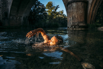 Man with beard on the river swimming