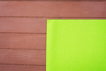 Fototapeta premium yoga green mat for practicing yoga on wood floor