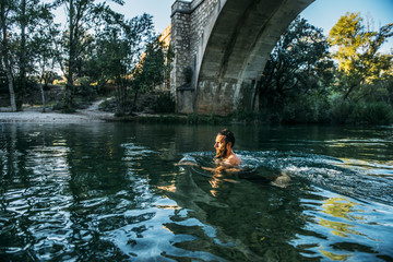 Man with beard on the river swimming
