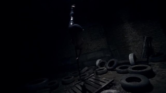 A strong guy performs a trick on a flying pylon in an abandoned building