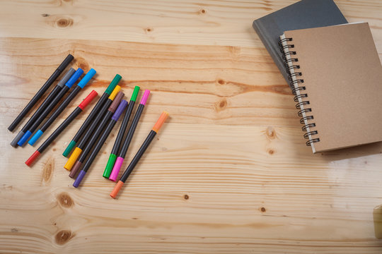 color pen on wood table with many equipment.