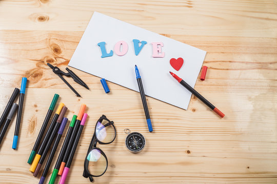 color pen on wood table with many equipment.