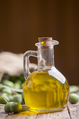 Olive oil and olives on wooden rustic table
