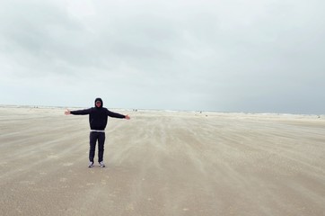 Mann bei einem Sturm an der Nordsee, Insel Rømø, Lakolk Strand, Dänemark