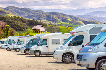 Close up motorhomes parked in a row on background green terraced rice field nature landscape.