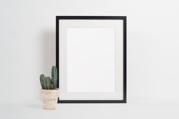 Black picture frame on white background with plant pot