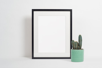 Black picture frame on white background with cactus - obrazy, fototapety, plakaty