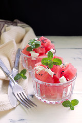 Summer salad with watermelon, feta cheese,mint  and black sesame.Rustic wooden table.Healthy summer salad.